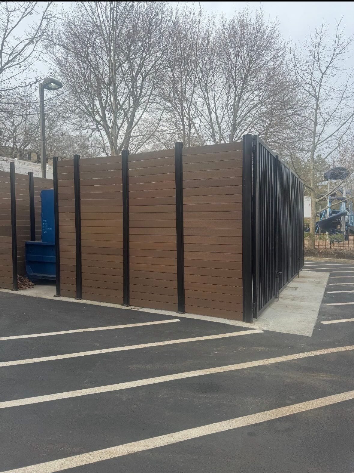 Dumpster enclosure with steel posts and concrete pad in Danvers